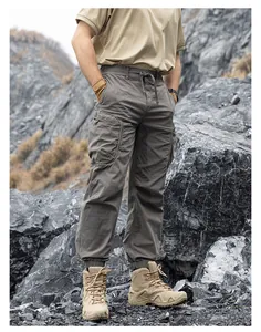 Detailed view of men's techwear cargo pants with multiple pockets in rugged setting