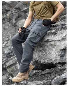 Detailed view of men's grey functional cargo pants with multi-pockets in outdoor setting