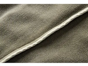 Close-up detail of textured fabric and white piping seam on men's cargo shorts