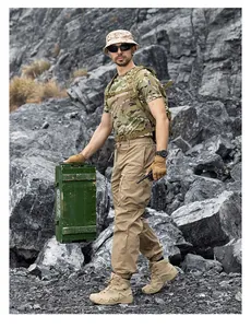 Men's loose techwear multi-pocket cargo pants shown in a rugged outdoor mountain setting