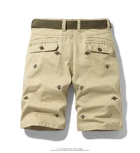 Detailed back view of khaki men's cargo shorts with embroidered bee patterns and belt.