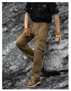 Men's khaki multi-pocket tactical cargo pants shown in a rugged outdoor rocky terrain