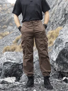 Men's brown loose functional cargo pants with multi-pockets in outdoor rocky setting
