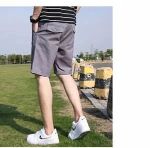 Detailansicht der Rückseite grauer Herren-Cargo-Shorts kombiniert mit Sneakern.