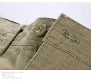 Primo piano di pantaloncini cargo in cotone kaki con bottone abbinato e cuciture rinforzate.