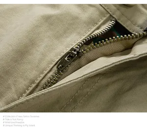 Macro della robusta cerniera in metallo e del tessuto twill kaki dei pantaloncini.