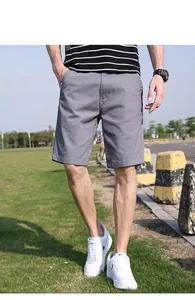 Nahaufnahme der lässigen grauen Cargo-Shorts für Herren mit weißen Sneakern und Sportuhr