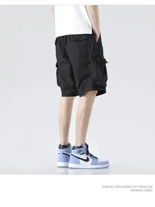 Close-up side view of men's black multi-pocket cargo shorts worn with casual sneakers