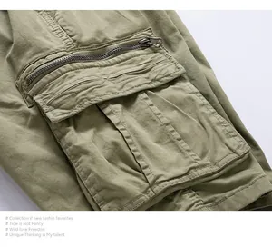 Close-up detail of the heavy-duty zipper and cargo pocket on olive green work shorts.