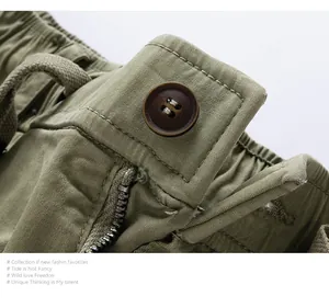 Close-up of olive green cargo shorts featuring button closure and zipper fly detail