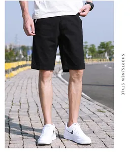 Dettaglio dei pantaloncini cargo neri larghi da uomo che mostra vestibilità e trama tessuto.
