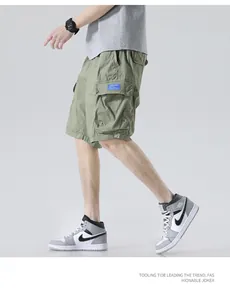 Side view of men's olive green multi-pocket cargo shorts with grey high-top shoes