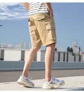 Detail view of men's khaki cotton cargo shorts with functional side pockets in outdoor setting