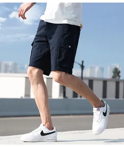 Men's navy cotton cargo shorts with side pockets in a stylish outdoor walking pose.