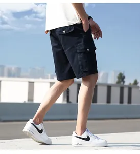 Detailed view of navy blue cargo shorts for men worn in an outdoor urban street setting.