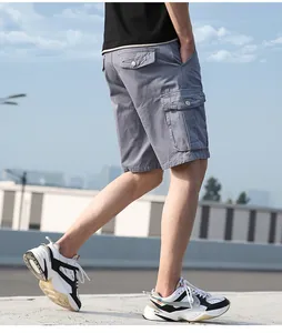 Close-up of grey men's cotton cargo shorts with multiple pockets and chunky sneakers.