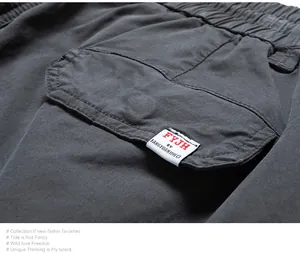 Close-up detail of pocket flap and brand label on men's vintage charcoal cargo pants.