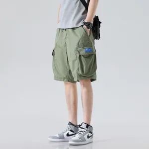 Men's olive green loose-fit cotton cargo shorts featuring multiple functional pockets