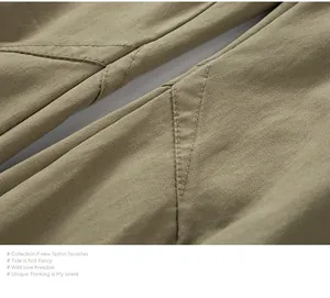 Vista macro detallada de la tela caqui duradera y las costuras dobles en pantalones techwear.