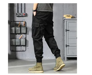 Vue détaillée du pantalon cargo noir rétro pour homme dans un décor industriel vintage