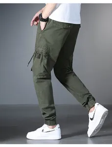 Detail side view of men's olive green cargo pants with multi-pockets and elastic cuffs