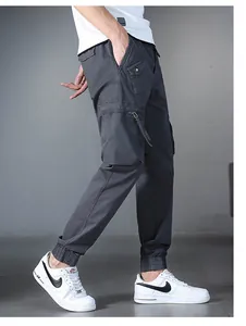 Side view of men's dark grey cargo joggers featuring multiple pockets and tapered cuffs.