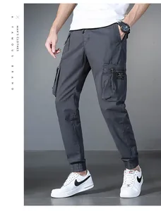 Detailed view of men's dark grey multi-pocket cargo pants paired with white sneakers