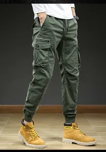 Detail view of men's vintage army green cargo pants with multi-pockets and jogger cuffs.