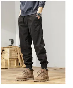 Close-up of men's vintage black elastic cargo pants with drawstring and jogger cuffs.