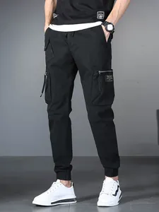 Stylish men's black multi-pocket drawstring cargo jogger pants with elastic cuffs.