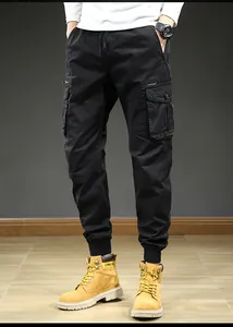 Lower body view of men's black cargo pants with multiple pockets and elastic cuffs
