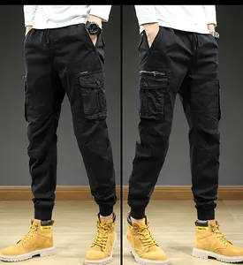 Close-up view of men's black vintage cargo pants featuring multi-pockets and cuffed hems