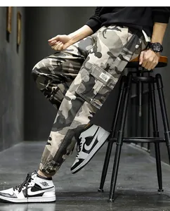 Close-up detail of men's camo cargo jogger pants made of cotton with utility pockets