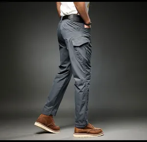 Side view of men's dark grey multi-pocket cargo pants paired with brown leather boots