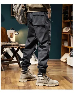 Detailed macro view of men's retro dark grey cargo jogger pants with functional side pockets.