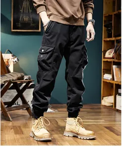 Detail view of men's black retro jogger cargo pants with tactical pockets and elastic cuffs