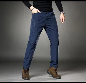 Men's navy blue multi-pocket cargo pants with functional zip detailing shown on model