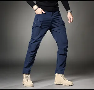 Detail view of men's slim fit navy blue cargo pants paired with tan tactical boots