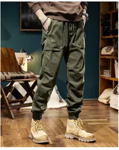 Full view of men's olive green cargo jogger pants with elastic cuffs in a lifestyle setting