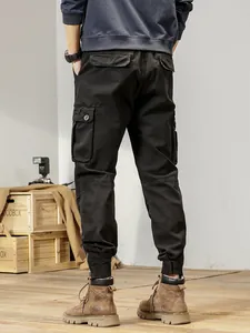 Men's American vintage black cargo pants with loose fit and jogger cuffs shown from back