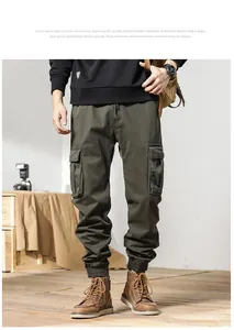 Detailed view of men's olive green vintage cargo pants with multiple pockets and cuffed hem