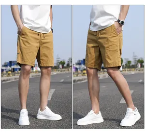 Detail view of men's vintage mustard yellow cargo shorts styled with white sneakers