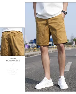 Detail view of men's mustard yellow loose cargo shorts with drawstring waist