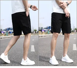 Close-up detail of men's casual black relaxed fit shorts on a street road background