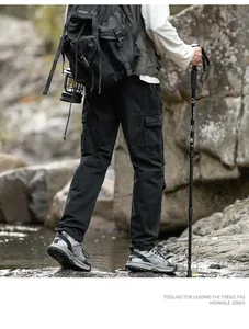 Vue arrière détaillée d'un pantalon cargo noir pour homme dans un décor de randonnée