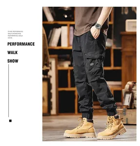 Side view of black multi-pocket cargo pants for men with joggers cuffs and street style