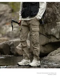 Détail d'un pantalon cargo d'extérieur pour hommes avec poches multiples et cordon.