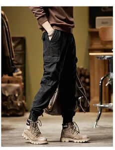 Detail view of men's black vintage cargo pants with side pockets and ribbed cuffs