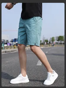 Detail shot of men's vintage teal work shorts in a relaxed summer fit outdoors.