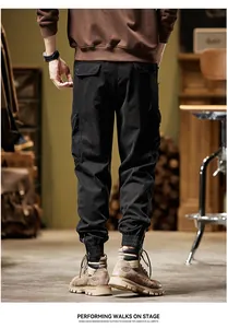 Detail view of men's black cargo pants with zippered ribbed cuffs and back pockets